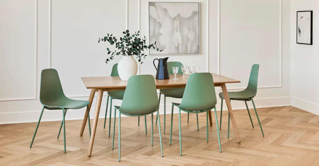 Aloe green Svelti dining chairs from Article around a dining table, adding vibrant color and sleek design